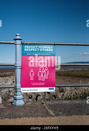 Proteggiti, rispetta gli altri - poster di Covid esposti lungo Morecambe Promenade, Lancashire Foto Stock