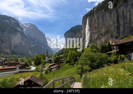 Vista panoramica della città e della valle di Lauterbrunnen con la cascata Staubbach sulla destra. Concetto per viaggiare in Svizzera durante l'estate. Foto Stock