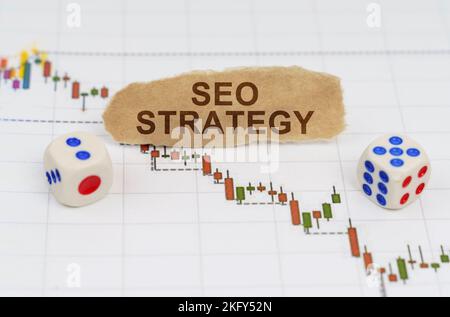 Concetto di business e finanza. Sulle tabelle commerciali, ci sono dadi e pezzi di carta con l'iscrizione - strategia SEO Foto Stock