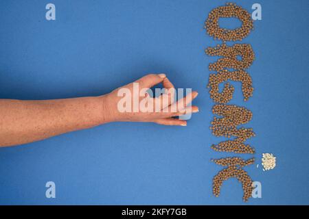 formazione della parola organica con legumi e cereali insieme con un braccio e dita che formano ok Foto Stock