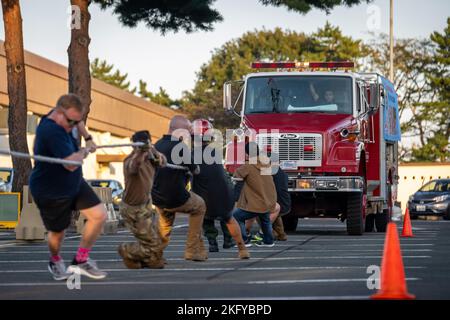 I membri dello Squadron, ingegnere civile del 35th, partecipano all'evento di estrazione dei camion antincendio durante il concorso annuale Fire Prevention Week Fire Muster alla base aerea di Misawa, Giappone, 14 ottobre 2022. Il Muster è il culmine di eventi divertenti progettati per riunire la comunità e i vigili del fuoco per promuovere la prevenzione delle incidenti antincendio attraverso l'istruzione. Foto Stock