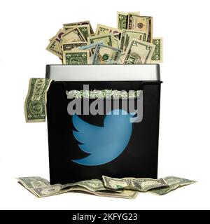 Un mucchio di dollari americani che vengono sminuzzati da una macchina con un logo twitter Foto Stock