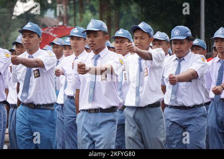 Gli studenti indonesiani delle scuole superiori con uniformi, marciando per celebrare l'indipendenza indonesiana Foto Stock