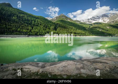 Lago di smeraldo alpino e montagne in primavera, Alpi del Gran Paradiso, Italia Foto Stock