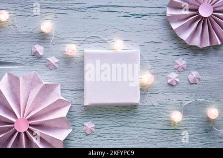 Ventilatori di carta, farfalle, fiori e luci festive in ghirlanda. Posa piatta, ornamenti primaverili, decorazioni su fondo in legno incrinato. Quadrato vuoto Foto Stock