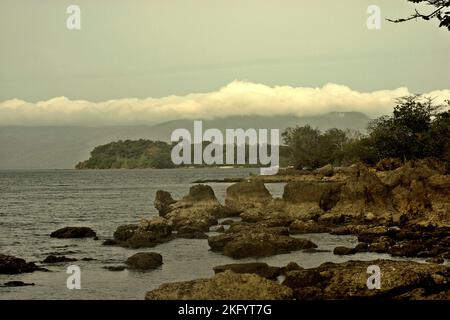 Spiaggia rocciosa nel Parco Nazionale di Ujung Kulon, Pandeglang, Banten, Indonesia. Foto Stock