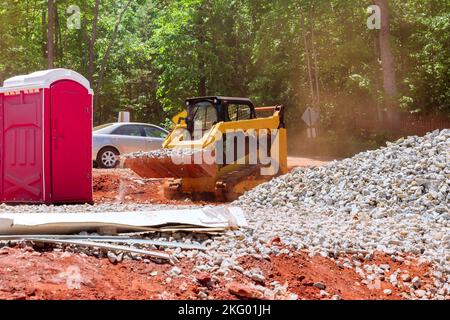 Durante un mini-caricatore a bobina, trasportare la pietra frantumata in vari cantieri Foto Stock