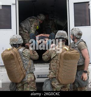 I militari del 374th Medical Group trasportano un membro del servizio ferito simulato su un bus di trasporto medico presso la base aerea di Yokota, Giappone, 18 ottobre 2022. Il team MDG del 374th ha simulato il trasferimento delle vittime dal trasporto di elicotteri aeromedical a un trasporto medico di massa destinato all'ospedale base MDG del 374th per le cure avanzate. Foto Stock