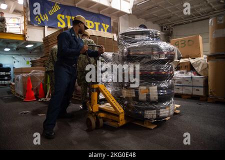 221018-N-YT061-1029 NORFOLK, Virginia (ott 18, 2022) Logistics Specialist 3rd Class Tyzael Keeling, da Portsmouth, Virginia, off-loads pneumatici nella baia hangar della portaerei di classe Nimitz USS Harry S. Truman (CVN 75), 18 ottobre 2022. Truman è la nave ammiraglia del gruppo di carrier Strike di Harry S. Truman ed è attualmente in porto presso la Naval Station Norfolk. Foto Stock