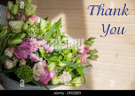 Bouquet con rosa rosa e scritta grazie, inglese. Bouquet luminoso di rose, Lisianthus, Alstroemeria e altri fiori. Presente per la primavera Foto Stock