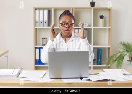 Lavoratrice che ha problemi a causa di un errore sul computer portatile in ufficio Foto Stock