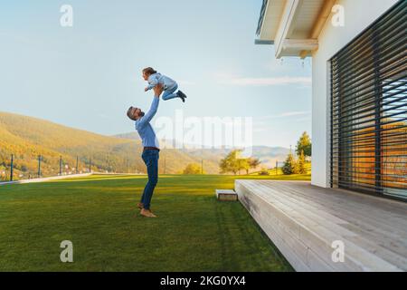 Padre con la sua figlia che si divertono nel cortile durante il giorno di autunno soleggiato. Foto Stock