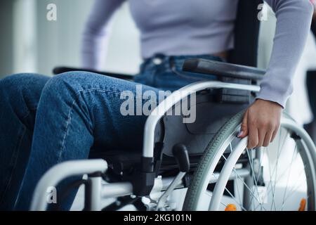 Primo piano di una giovane donna in sedia a rotelle in ospedale. Foto Stock