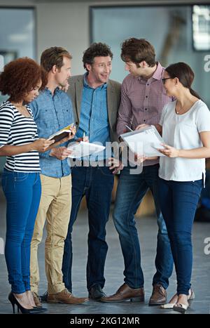 Insieme, fanno la squadra migliore, un gruppo di colleghi che parlano in ufficio. Foto Stock