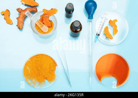 Ricerca medica delle proprietà curcuma con l'aiuto di attrezzature di laboratorio, donna in guanti di prova curcuma polvere. Vista dall'alto. Foto Stock