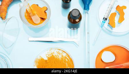 Ricerca medica delle proprietà curcuma con l'aiuto di attrezzature di laboratorio, donna in guanti di prova curcuma polvere. Vista dall'alto. Foto Stock