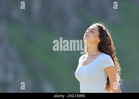 Casual rilassato donna respirando aria fresca in piedi in natura Foto Stock