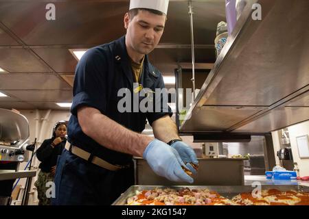 221022-N-CM110-1046 EAST CHINA SEA (OTT 22, 2022) – il Lt. Drew Pendock, l'ufficiale della wardroom, fa una pizza nella cucina della wardroom a bordo del portatore d'assalto anfibio USS Tripoli (LHA 7) 22 ottobre 2022. Tripoli opera nell'area delle operazioni della flotta 7th degli Stati Uniti per migliorare l'interoperabilità con alleati e partner e fungere da pronta forza di risposta per difendere la pace e mantenere la stabilità nella regione dell'Indo-Pacifico. Foto Stock