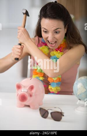 la donna sconvolta deve rompere una banca del piggy Foto Stock
