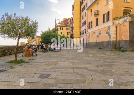 Gli abitanti del luogo che passavano la giornata si sedettero su panchine e chiacchieravano in Via Pecunia, Riomaggiore cinque Terre, Italia settentrionale. Settembre 2022 Foto Stock