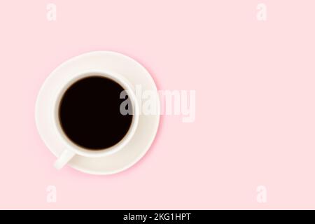 Tazza con caffè nero su sfondo rosa. Composizione minima con spazio di copia. Foto Stock