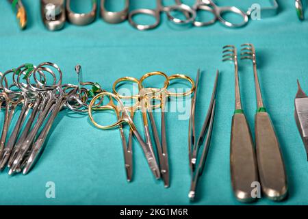 Prepararsi per gli strumenti chirurgici durante il funzionamento, forbici, pinze e bisturi, forbici diritta utilizzata per tagliare il materiale da sutura dove viene utilizzato come forbici curva Foto Stock