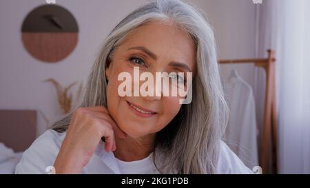 Ritratto primo piano headshot anziano anziano maturo 50s signora Caucasian vecchio grigio-capelli 60s donna femmina guardando la fotocamera sorriso coccole toccare rugoso Foto Stock