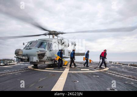 MAR BALTICO (ott 24, 2022) i marinai rimuovono i cunei e le catene da un elicottero MH-60R Seahawk, attaccato all'elicottero Maritime Strike Squadron (HSM) 79, sul ponte di volo del cacciatorpediniere di missili guidati di classe Arleigh Burke USS Roosevelt (DDG 80), 24 ottobre 2022. Roosevelt si trova in una distribuzione programmata nell'area operativa delle forze Navali USA in Europa, impiegata dalla U.S. Sesta flotta per difendere gli interessi degli Stati Uniti, alleati e partner. Foto Stock