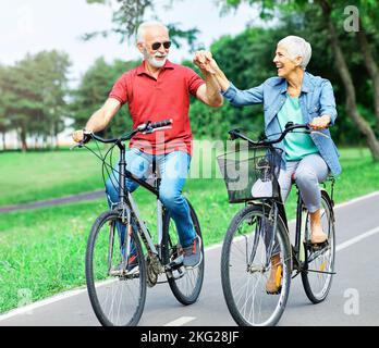 coppia anziana felice anziano amore insieme pensionamento bicicletta uomo donna matura divertimento Foto Stock