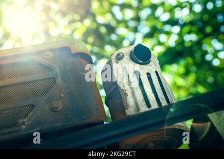 Tubo di scarico di un trattore a due passi da vicino su uno sfondo sfocato. Tempo estivo soleggiato Foto Stock