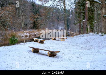 Quattro gradini di legno da due tronchi e una tavola in piedi sulla riva del fiume. Parco naturale Skanaiskalns. Novembre è la prima neve a Mazsalaca in Lettonia Foto Stock