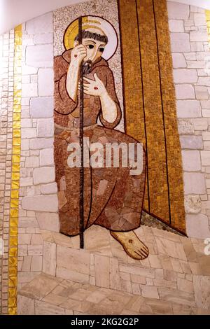 Mosaico della chiesa inferiore nella basilica di Padre Pio, San Giovanni Rotondo, Italia. San Francesco sulla soglia del santuario di San Michele a Monte Sant'Ang Foto Stock