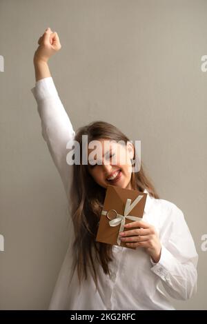 ragazza eccitata felice di ricevere un buono regalo o un buono Foto Stock