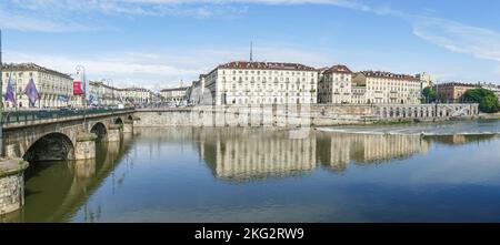 Vista extra grandangolare dei murazzi di Torino con edificio che si riflette nell'acqua del po Foto Stock