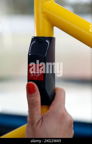 Pulsante di fermata dell'autobus per scendere. Primo piano a portata di mano. Trasporti pubblici. Foto Stock