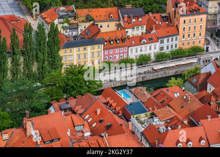 Città di Lubiana in Slovenia, vista sopra le case piastrellate rosse su entrambi i lati del fiume Lubiana dalla città vecchia. Foto Stock