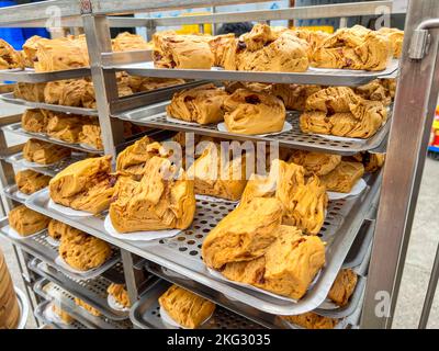 Ciambelle di zucchero di canna cotte al vapore appena sfornate in lotti da una fabbrica di lavorazione degli alimenti Foto Stock