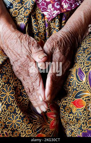 Primo piano delle mani di una donna anziana di 80 anni. Vecchia donna cambogiana a casa. Primo piano sulle mani. Phnom Penh. Cambogia. Foto Stock