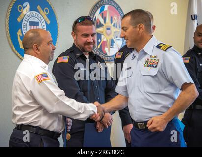 Frank DeMarco, supervisore delle operazioni del distretto 2 dei servizi di emergenza della contea di Galveston, scuote le mani con la Guardia Costiera CMdR. Mike cortese, capo della risposta al Sector Houston-Galveston, durante una cerimonia al Sector di Houston, Texas, 26 ottobre 2022. Quando un'imbarcazione trainante e due imbarcazioni da diporto si scontrarono nei pressi dell'isola di Goat il 30 luglio 2022, l'EMS della contea di Galveston e il Dipartimento dei vigili del fuoco Volontario di Port Bolivar lavorarono insieme a un equipaggio della Guardia Costiera di Galveston per salvare sei persone dall'acqua. Foto Stock