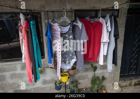 Medellin, Antioquia, Colombia - Settembre 13 2022: Appendere e asciugare i vestiti del sole sopra in una corda contro il muro di mattoni Foto Stock