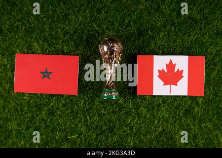 20 novembre 2022, Doha, Qatar. Bandiere del Marocco e del Canada e il trofeo della Coppa del mondo FIFA sul prato verde dello stadio. Foto Stock