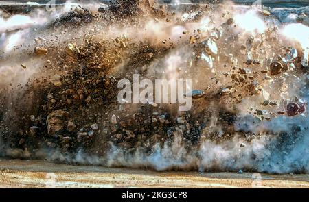 Nuvole di polvere e particelle di roccia durante la sabbiatura estrema del denotatore nel cantiere dell'Oman Foto Stock