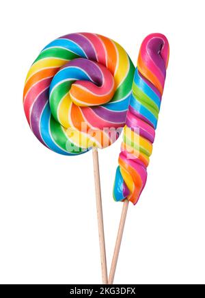 Due colorate lollipop swirl spirale grandi caramelle su bastone di legno arcobaleno colorato isolato su sfondo bianco Foto Stock