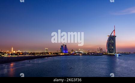 Tramonto a Jumeirah, con sulla sinistra il Jumeirah Hotel, il Burj al Arab e sullo sfondo la Marina di Dubai, Emirati Arabi Uniti Foto Stock