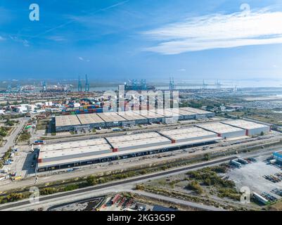 Ripresa aerea del molo di carico del magazzino industriale in cui molti camion con semirimorchi caricano merci nella FOS sur Mer, Francia Foto Stock
