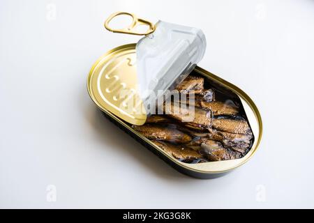 Gli spratti con olio nella lattina aperta possono sul fondo bianco Foto Stock