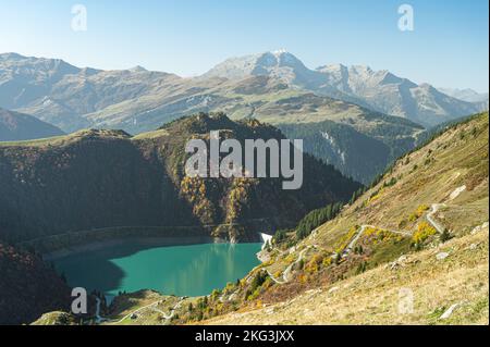 Prospettiva di lago di montagna circondato da pascoli alpini, boschi e prati fioriti con erba di cotone nel sud della Francia. Foto Stock