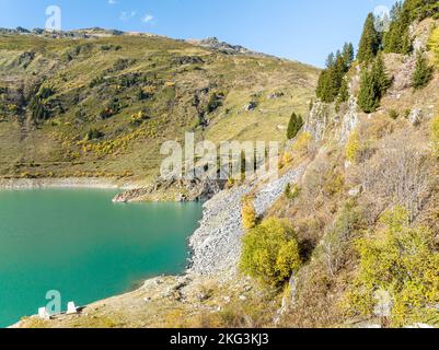 Prospettiva aerea del lago Beaufortain in Savoia circondato da pendii rocciosi nelle alpi francesi meridionali catturati dall'angolo. Foto Stock