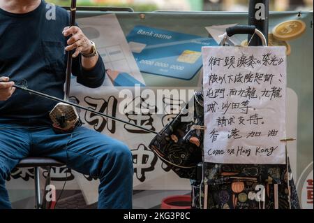 Hong Kong, Cina. 19th Nov 2022. Un musicista suona 'Glory to Hong Kong' e 'Do You Here the People Sing?' Su un erhu di fronte alla Stazione di Quarry Bay a Hong Kong. "Glory to Hong Kong”, considerato un inno non ufficiale delle proteste a favore della democrazia del 2019, ha fatto notizia ultimamente perché è stato scambiato per l'inno nazionale cinese in occasione di numerosi eventi internazionali di rugby. A Hong Kong, permangono dubbi circa la legalità di suonare o di eseguire questa canzone in pubblico ai sensi della legge sulla sicurezza nazionale. Credit: SOPA Images Limited/Alamy Live News Foto Stock