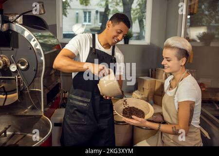 Due sorridenti maestri arrosti che lavorano insieme Foto Stock